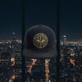 The 23rd Floor Snapback with circular ring logo, navy and gold, city skyline background
